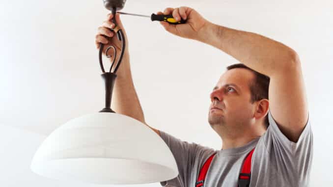 Elektriker montiert eine Lampe